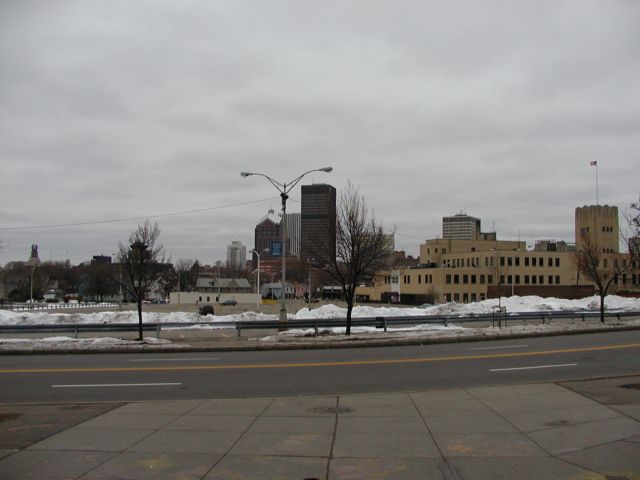 Picture Rochester NY New York New Years Day Rochester NY Skyline as seen from the steps of Monroe Junior High School. From left, Times building, former revolving restaurant behind tree, Hyatt, Bausch and Lomb, Lincoln Tower, Xerox Tower, Midtown Plaza, HSBC Building, and Mornoe Square the former Sears and Roebuck Company building flying the American flag. January 2nd 2003 POD Rochester NY New York Picture Of The Day December view picture photo image pictures photos images, January 2nd 2003 POD