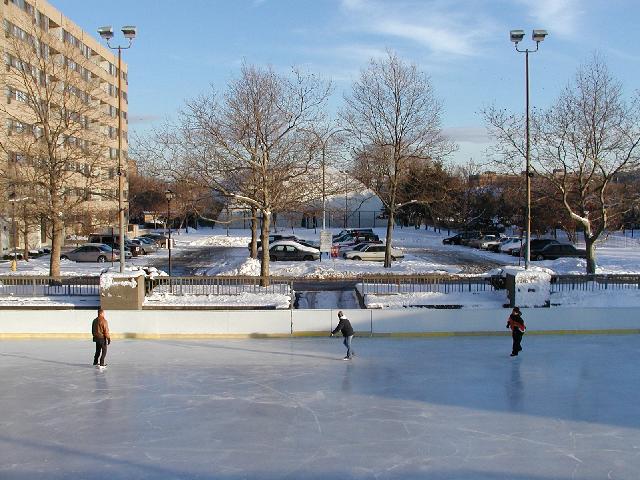 Rochester NY New York December 11th 2002 POD Ice Skaters Manhattan Square Park Ice Skating Rink Manhattan Square Apartments Snow Coverd Parking Lot Indoor Tennis Court In Background On A Late Fall Blue Sky Rochester Afternoon Rochester NY Picture Of The Day Photo Photos Pictures Image Images